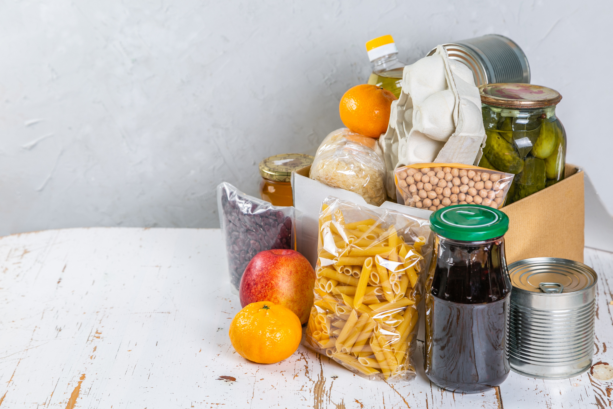 Food Donations in Box in Kitchen Background